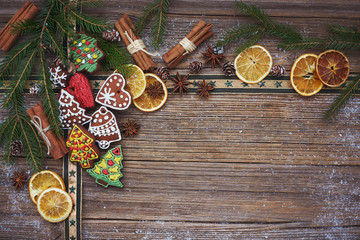 Christmas background. Christmas tree, homemade gingerbread cookies, cinnamon sticks on old wooden background. Copy space 