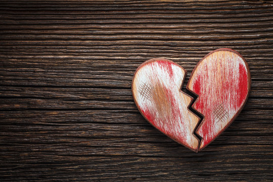 Broken heart on wooden background