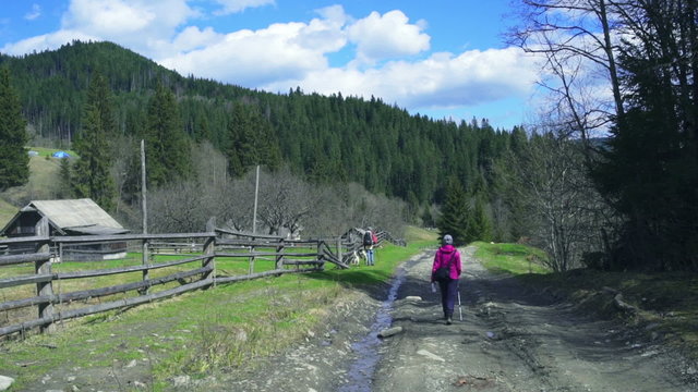 tourists walking along old abandoned farm in forest