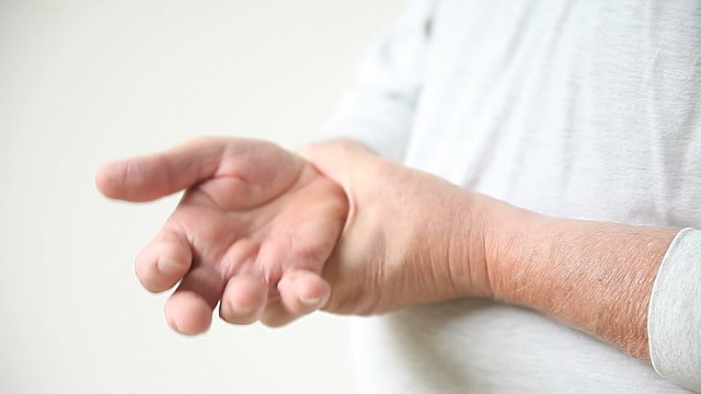 A man checks the area around his sore thumb.