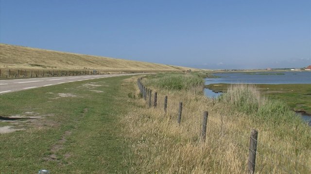 DE PUTTEN, PETTEN, THE NETHERLANDS -  landside of the Hondsbossche and Pettemer Zeewering  + bird reserve in coastal landscape - hold + pan right