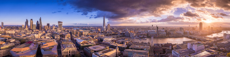 Fototapeta na wymiar Panoramic skyline of the east and south part of London with beautiful clouds at sunset. This wide view includes the bank district, the Tower Bridge, Shard tower, Tate Modern Museum and London Eye