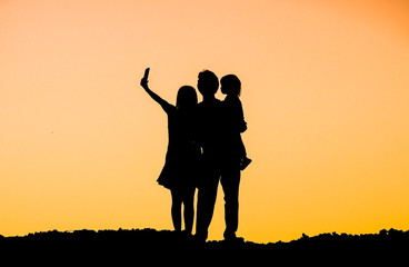 Fototapeta na wymiar People in a family doing selfie silhouette