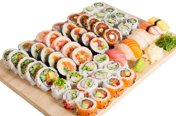 Assorted sushi rolls on a wooden board isolated on white backgro