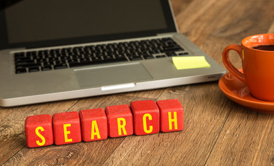 Search written on a wooden cube in a office desk