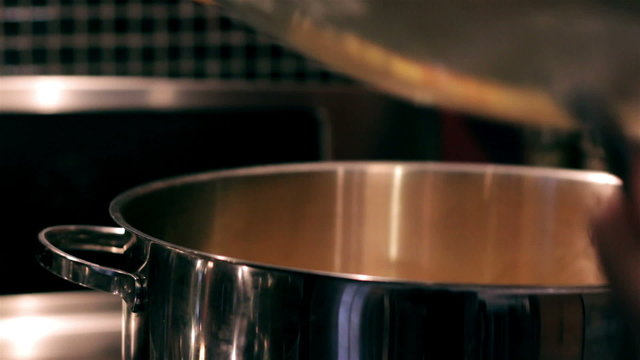 Closeup on a man stirring simmering soup in a pot evening