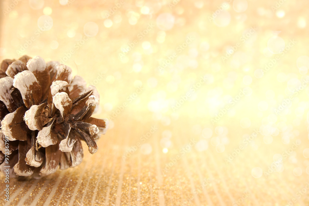 Wall mural pinecone on golden shiny background with copy space for text. ho