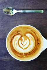 cup of latte art coffee on wooden background