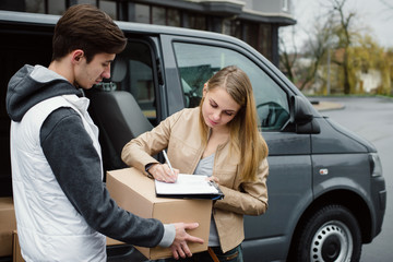 Customer signing delivery note from postage service