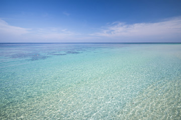 Fototapeta na wymiar tropical beach with blue sky and calm blue sea surf