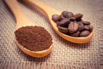 Ground coffee and grains with wooden spoon on jute canvas