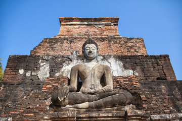 Fototapeta premium Statue of seated Buddha at ancient temple of Wat Mahathat in Sukhothai, Thailand