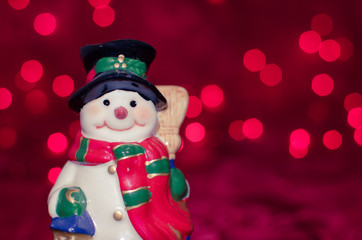 Ceramic snowman on red bokeh background