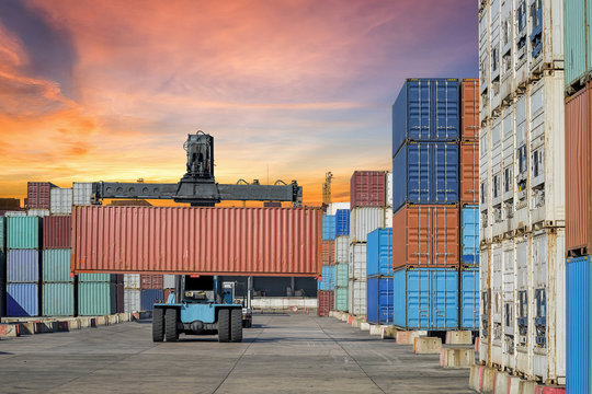 forklift handling the container box in logistic zone on sunset