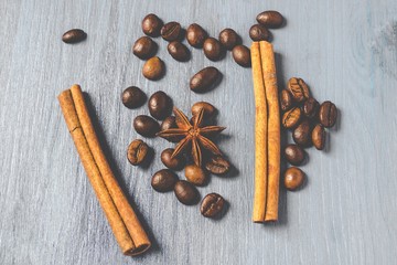 Coffee beans, cinnamon sticks and star anise on gray wooden table, with matte effect