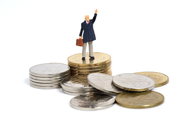 Miniature business man stand on coins