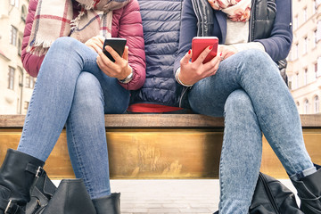 Close up of couple of girlfriends in disinterest moment with mobile smart phones - Concept of...
