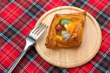 danish pastry with fruits on red fabric plaid
