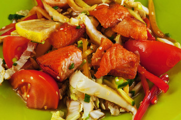 Warm salad with salmon and vegetables on a plate