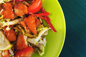 Warm salad with salmon and vegetables on a plate