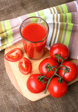 A glass of tomato juice and ripe tomatoes..