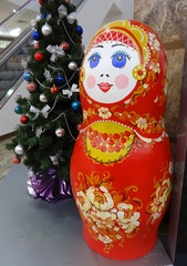 Большая деревянная кукла матрешка возле Новогодней елки