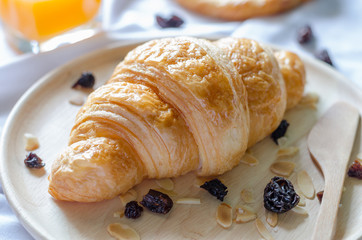 Croissant in wooden dish with blurred background