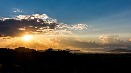 Crepuscular sun rays during sunset over the hill