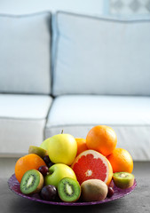 Fresh fruits on table in living room, close up