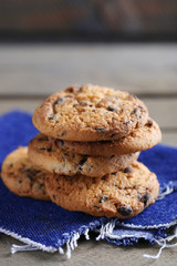 Cookies with chocolate crumbs on wooden table against blurred background, close up