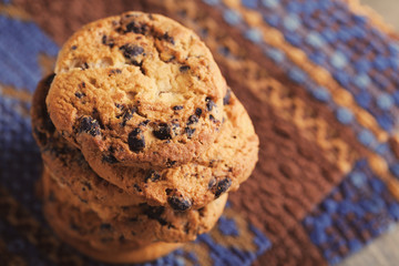 Cookies with chocolate crumbs on ornament napkin against blurred background, close up