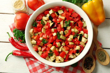 Ratatouille before cooking and ingredients, on wooden background