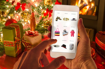 Christmas online shopping with phone. Christmas tree, gifts, lights and decorations. 