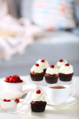 Beautiful chocolate cupcakes and cup of tea,  on table