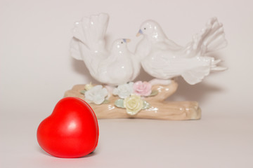 Red heart and a pair of white doves on the background