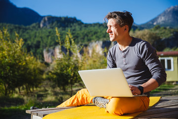 Freelancer working on computer over the mountain landscape
