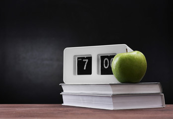 Apple and books on desk background