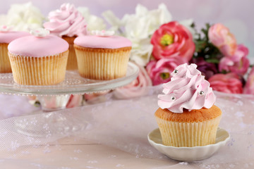 Tasty cupcakes on bright background