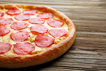 Tasty pizza with salami on wooden background, close up