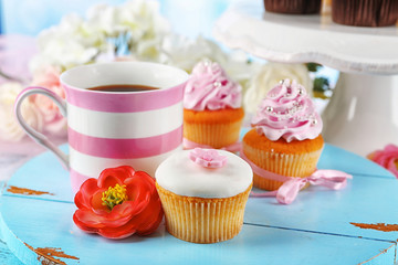 Tasty cupcakes on tray, on light background