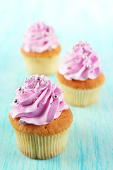 Tasty cupcakes on color wooden background