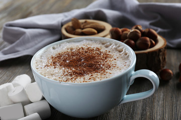 Cup of hot cacao with marshmallow on wooden background, close up