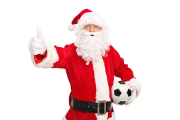 Fototapeten Santa holding a football and giving thumb up © Ljupco Smokovski