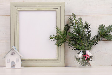 Christmas and New Year background. Empty picture frame,  fir branch and on white background. Copy space image. Scandinavian style home interior decoration
