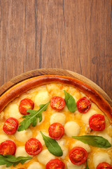 Pizza Margherita with arugula on wooden background
