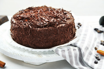 Tasty chocolate cake on wooden table, on light background