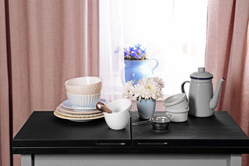 Kitchenware on table on window background