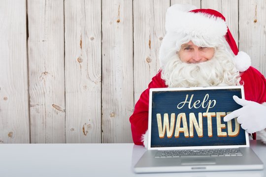 Composite image of santa using laptop