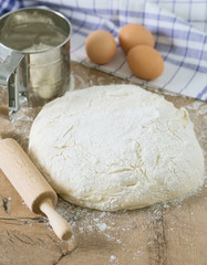 wooden rolling pin with freshly prepared dough