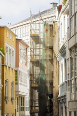 Fototapeta premium construction workers in scaffolding on the building facade for restore, repair and renovate 